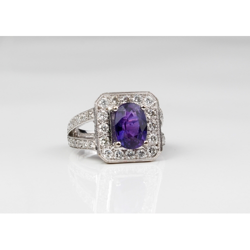 225 - An 18ct white gold, purple sapphire and diamond cluster ring - Birm. hallmarks, maker WEB, the oval ... 