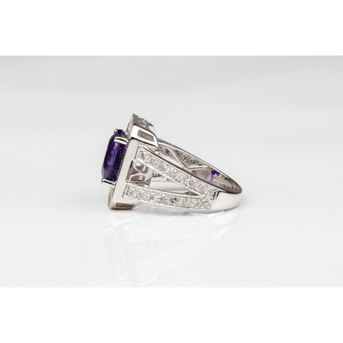 225 - An 18ct white gold, purple sapphire and diamond cluster ring - Birm. hallmarks, maker WEB, the oval ... 