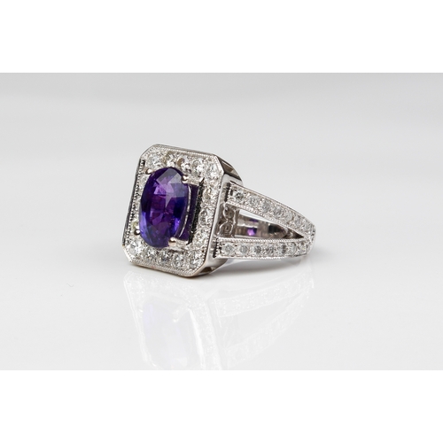 225 - An 18ct white gold, purple sapphire and diamond cluster ring - Birm. hallmarks, maker WEB, the oval ... 