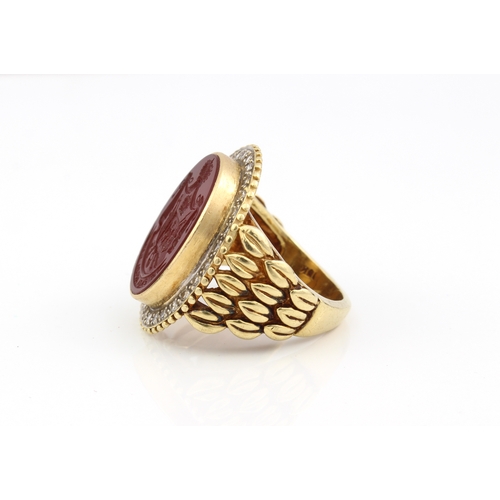 214 - An 18ct yellow gold, carnelian intaglio and diamond signet ring - marked '18K', the oval carnelian i... 