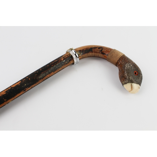 126 - An ebonised walking cane (probably early 20th century): the curved handle with a white metal mounted... 