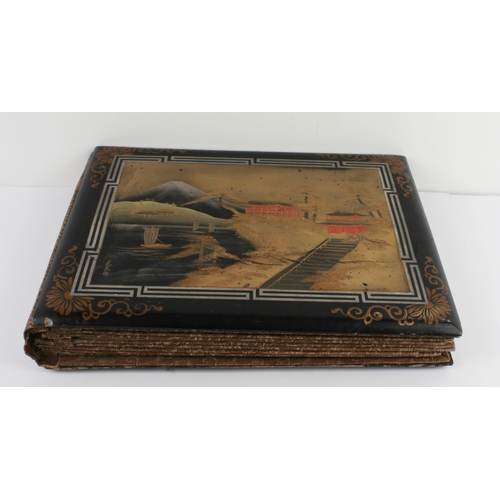 68 - A Japanese lacquer postcard album - 1920s-30s, the black lacquer cover decorated with a handpainted ... 