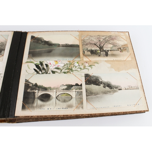 68 - A Japanese lacquer postcard album - 1920s-30s, the black lacquer cover decorated with a handpainted ... 