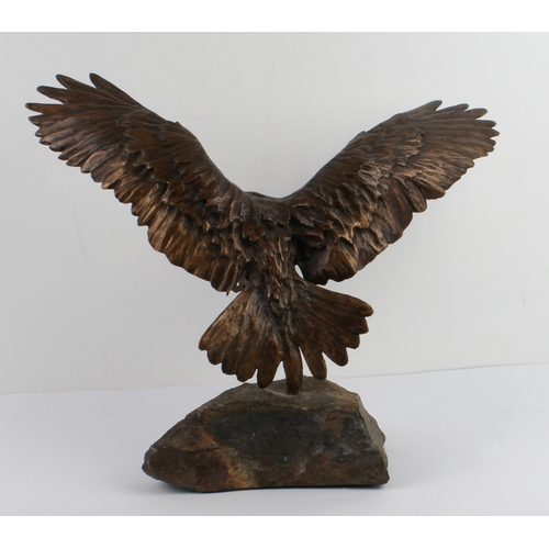 93 - A bronze figure of an eagle in flight - late 20th century, with wings and talons outstretched as if ... 