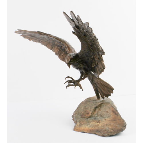 93 - A bronze figure of an eagle in flight - late 20th century, with wings and talons outstretched as if ... 