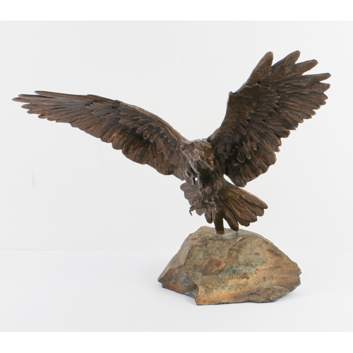 93 - A bronze figure of an eagle in flight - late 20th century, with wings and talons outstretched as if ... 