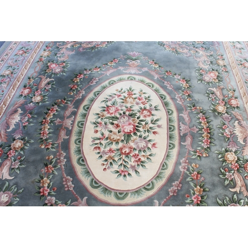 592 - A Chinese carpet with a teal ground, ivory central medallion surrounded by vases of flowers, one mai... 