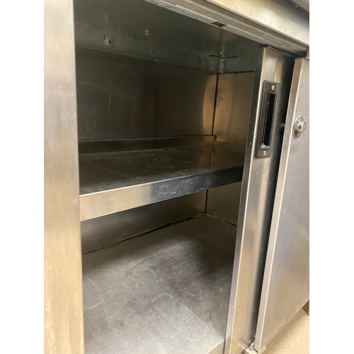 12 - Stainless steel worksurface with a lockable cabinet below. Cabinet has two sliding doors and one int... 