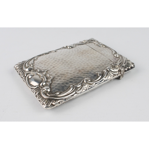 101 - A large silver card case with planished finish and bold scrolling border, engraved initials M.H.S., ... 