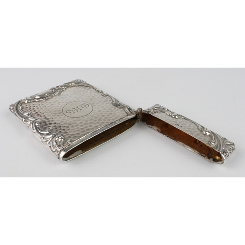 101 - A large silver card case with planished finish and bold scrolling border, engraved initials M.H.S., ... 