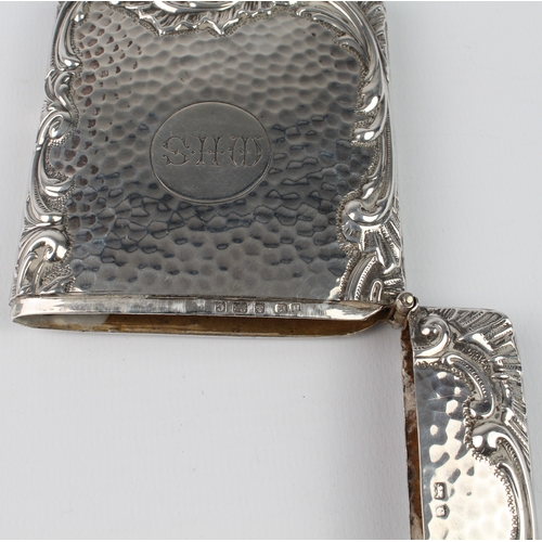 101 - A large silver card case with planished finish and bold scrolling border, engraved initials M.H.S., ... 