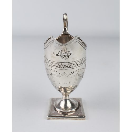 104 - A George III cream jug of helmet form - maker's mark mis-struck, London 1815, with chased foliate sw... 