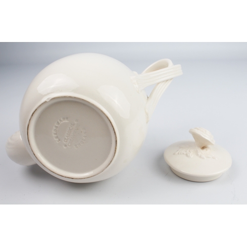 29 - A reproduction Wedgwood creamware teapot and a Wedgwood buff-glazed three-piece cruet set