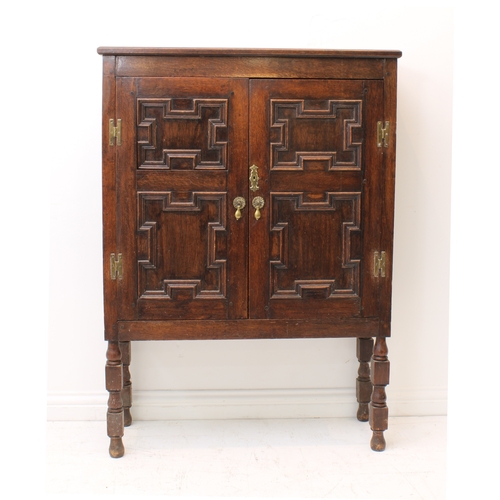 470 - A 19th century panelled oak cabinet on stand - the chamfered top over a pair of geometric mitre pane... 