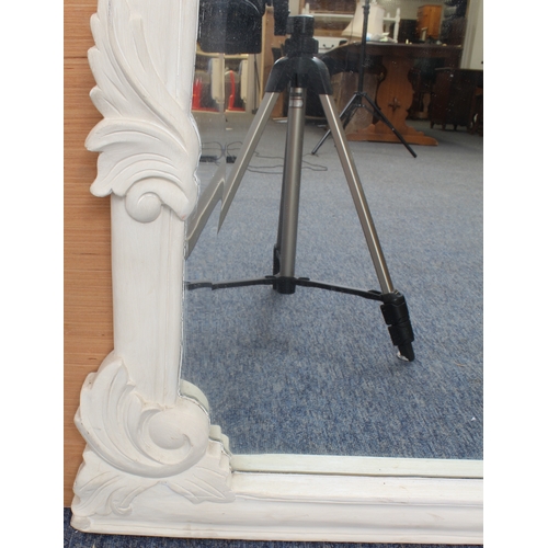 533 - A carved off-white painted wooden overmantle mirror in the 19th century style - the shaped, bevelled... 