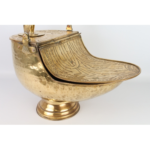 580 - A large early 20th century brass coal scuttle - embossed in the Art Nouveau manner, swing-handle and... 