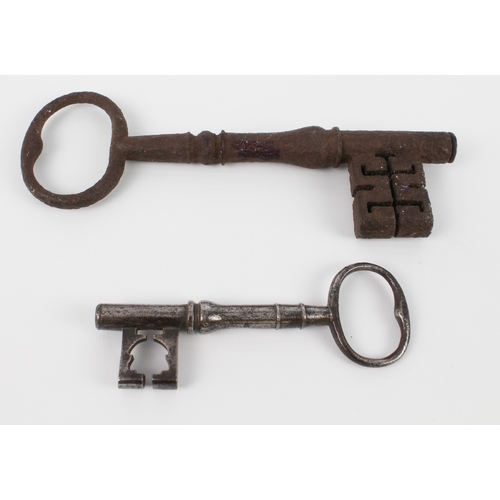 588 - A large polished iron key (12.5 cm) and another larger unpolished example (20.5 cm)