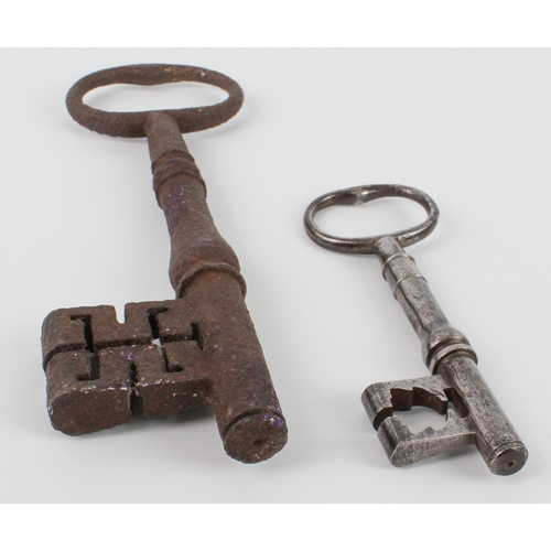 588 - A large polished iron key (12.5 cm) and another larger unpolished example (20.5 cm)