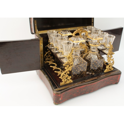 608 - An early 19th century French Boulle-style cave à liqueur or travelling decanter set - the serpentine... 