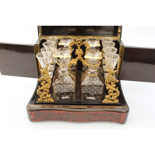 608 - An early 19th century French Boulle-style cave à liqueur or travelling decanter set - the serpentine... 