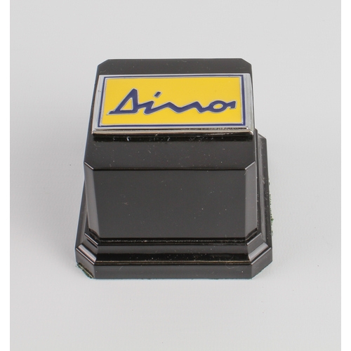 633 - An enamel and chrome Ferrari Dino car badge mounted as a paperweight, LWH 7.5 x 7.5 x 5.5 cm.