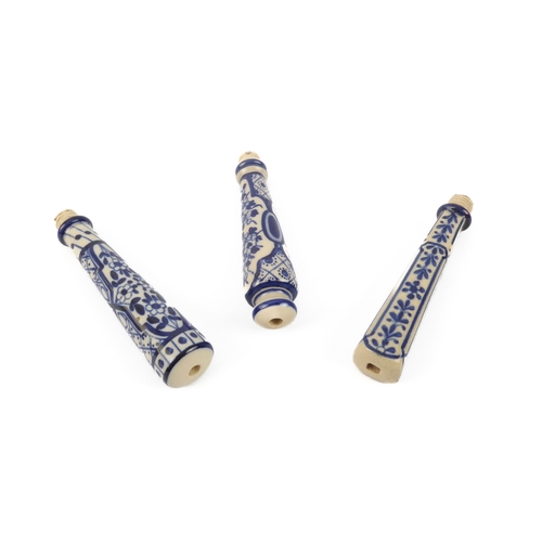 641 - Three stone-glazed blue and white knife handles or bell-pulls, longest 9 cm.