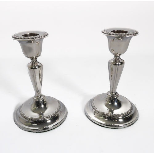 138 - A pair of Edwardian silver table candlesticks - Fordham & Faulkner, Sheffield 1909, the urn nozzles ... 