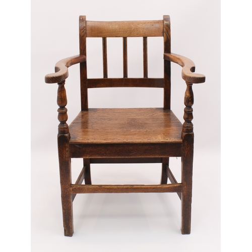 412 - A George III oak elbow chair - with three-rail back, solid seat, swept arms and tapered square legs ... 