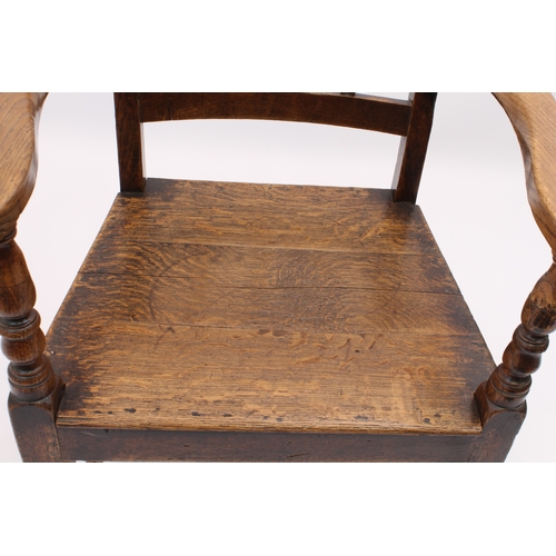 412 - A George III oak elbow chair - with three-rail back, solid seat, swept arms and tapered square legs ... 