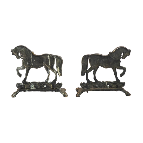 597 - A mirrored pair of 19th century brass door stops in the form of horses - standing on foliate scrollw... 