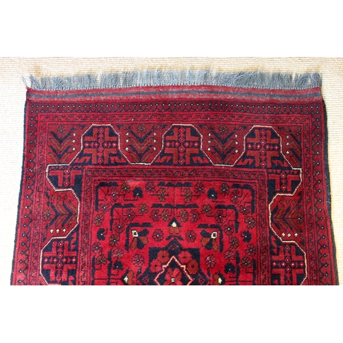 564 - An Afghan Kundoz rug - with three square medallions and all over floral decoration on a red field, w... 