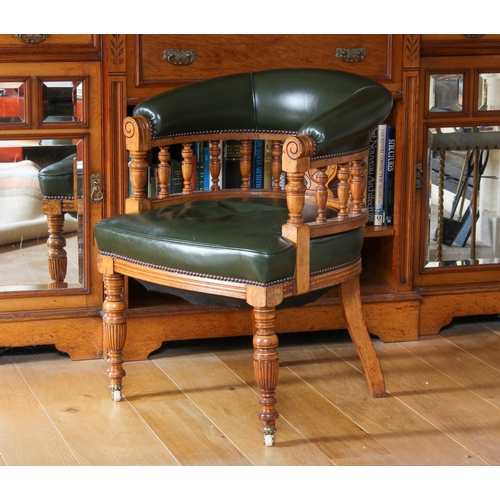 427 - An Edwardian honey oak and green leather desk chair - the curved back with turned balustrade spindle... 