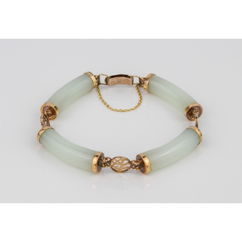 216 - A Chinese 9ct gold and celadon jade bracelet - with four curved, cylindrical jade bars joined by pie... 