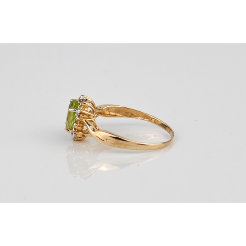 242 - A 9ct yellow gold, peridot and diamond ring - stamped '9K', the oval cut peridot, approx. 6.75 x 4.7... 