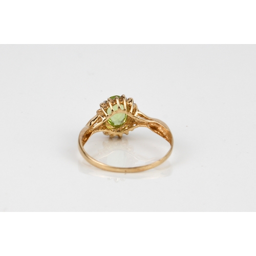 242 - A 9ct yellow gold, peridot and diamond ring - stamped '9K', the oval cut peridot, approx. 6.75 x 4.7... 