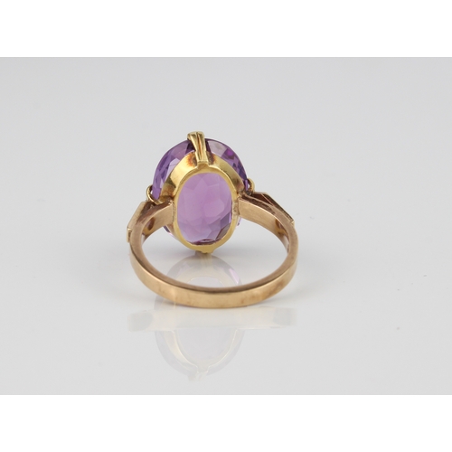 207 - A 9ct gold ring and amethyst ring - stamped '9CT', the large 14.5 x 11mm oval cut amethyst over swor... 