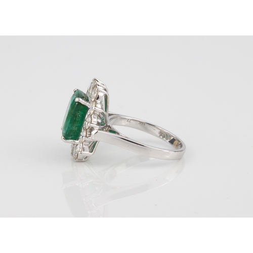 184 - An 18ct white gold, emerald and diamond cluster ring - stamped '18K', the 11 x 9mm. rectangular cush... 