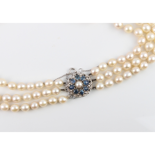 223 - A cultured pearl three-row necklace with 9ct white gold, sapphire and pearl clasp - the clasp hallma... 