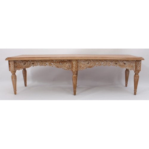 513 - An Oriental carved, limed hardwood long stool or bench - modern, the cleated, moulded seat over a fo... 