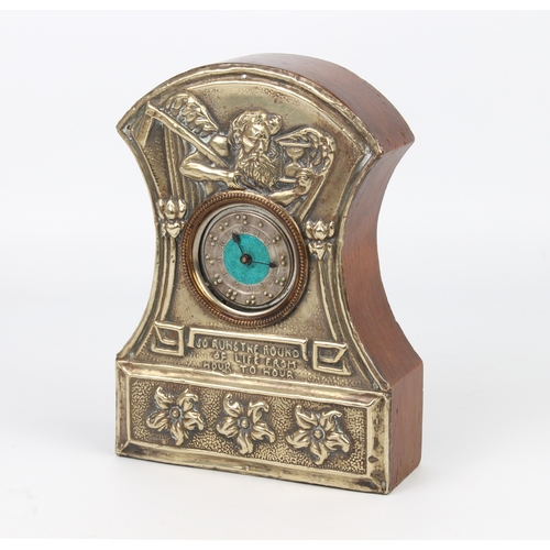 262 - An Arts and Crafts mantle clock; the face silver plated with embossed design of Old Father Time and ... 