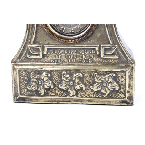 262 - An Arts and Crafts mantle clock; the face silver plated with embossed design of Old Father Time and ... 