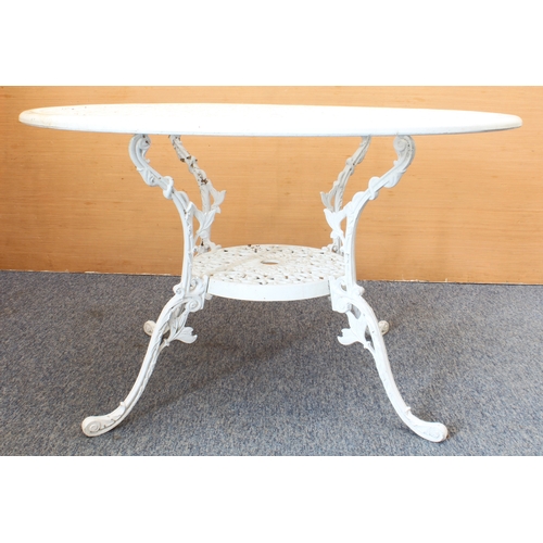 539 - A white-painted cast metal circular garden table and four chairs - the table with pierced leafy scro... 