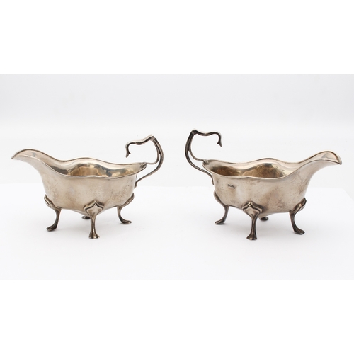 130 - A pair of Edwardian Art Nouveau style silver sauce boats - Walker & Hall, Sheffield 1911, of four-lo... 