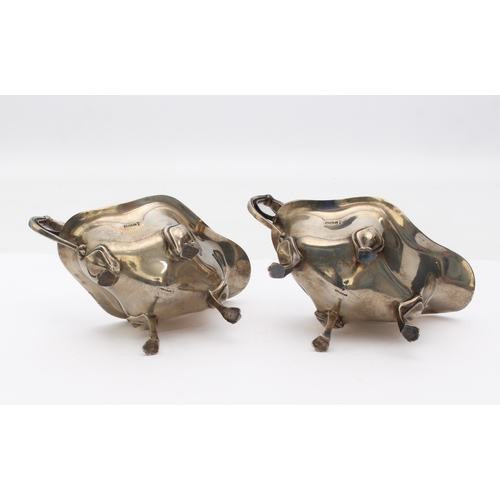 130 - A pair of Edwardian Art Nouveau style silver sauce boats - Walker & Hall, Sheffield 1911, of four-lo... 