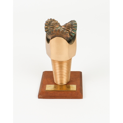 755 - An unusual paperweight in the form of a bronze North Sea oil drill-bit - mounted on a wooden plinth ... 