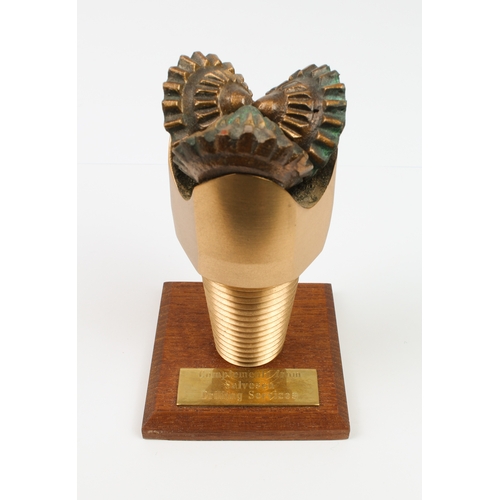 755 - An unusual paperweight in the form of a bronze North Sea oil drill-bit - mounted on a wooden plinth ... 