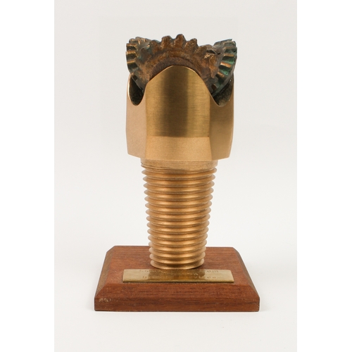 755 - An unusual paperweight in the form of a bronze North Sea oil drill-bit - mounted on a wooden plinth ... 