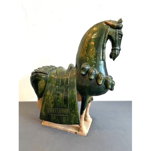 77 - A Chinese sancai glazed earthenware figure of a caparisoned horse - 20th century, in the Tang dynast... 