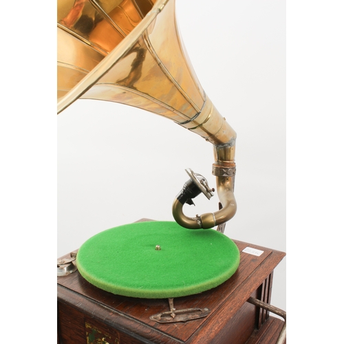 779 - A reproduction HMV oak-cased horn gramophone - fitted with a No.54 soundbox, with winding handle and... 