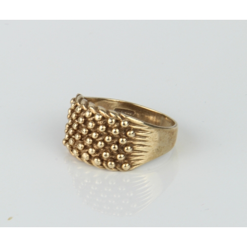 198 - A vintage 9ct yellow gold ring - marked 375, with beaded decoration over fluted shoulders, size T.